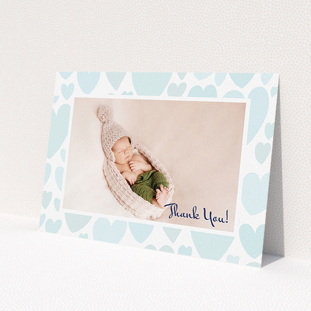 A baby card design named 'Pastel Hearts'. It is an A5 card in a landscape orientation. It is a photographic baby card with room for 1 photo. 'Pastel Hearts' is available as a flat card, with tones of blue and white.