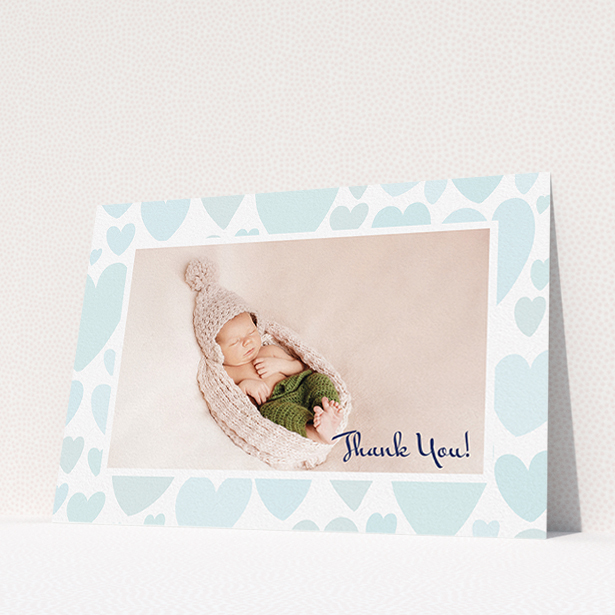 A baby card design named "Pastel Hearts". It is an A5 card in a landscape orientation. It is a photographic baby card with room for 1 photo. "Pastel Hearts" is available as a flat card, with tones of blue and white.
