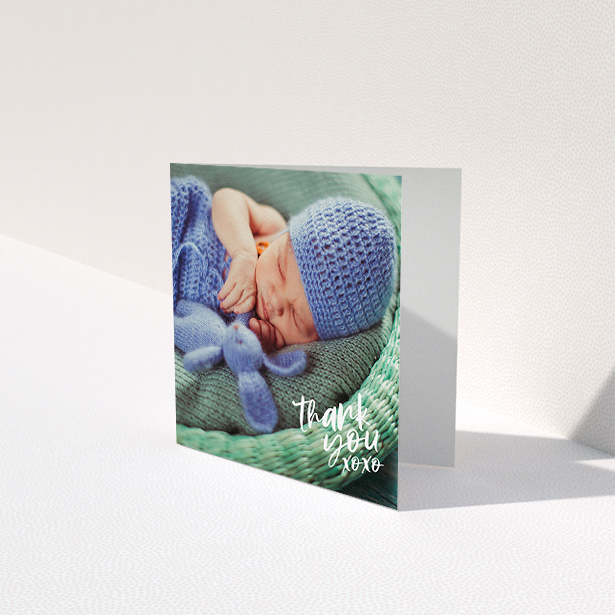 A baby card design titled "Thanks In the Corner". It is a square (148mm x 148mm) card in a square orientation. It is a photographic baby card with room for 1 photo. "Thanks In the Corner" is available as a folded card, with mainly white colouring.
