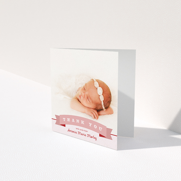 A baby thank you card named "Big Banner". It is a square (148mm x 148mm) card in a square orientation. It is a photographic baby thank you card with room for 1 photo. "Big Banner" is available as a folded card, with tones of pink and white.