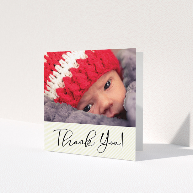 A baby thank you card template titled 'Cursive Thanks'. It is a square (148mm x 148mm) card in a square orientation. It is a photographic baby thank you card with room for 1 photo. 'Cursive Thanks' is available as a folded card, with mainly cream colouring.