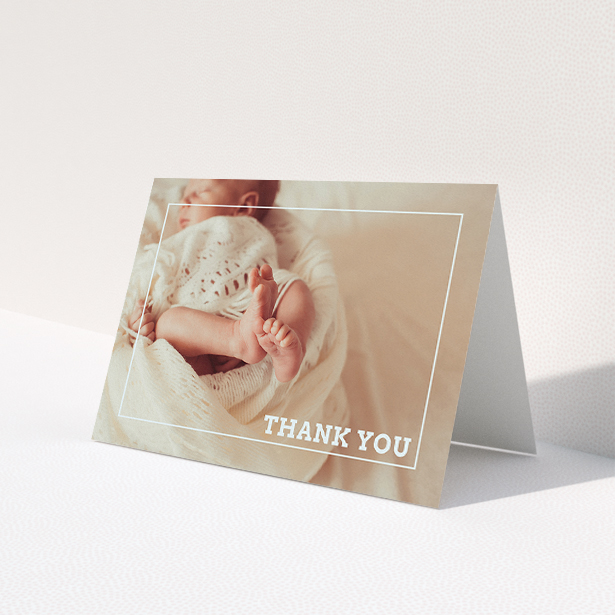A baby thank you card called 'Over Photo Frame'. It is an A5 card in a landscape orientation. It is a photographic baby thank you card with room for 1 photo. 'Over Photo Frame' is available as a folded card, with mainly white colouring.