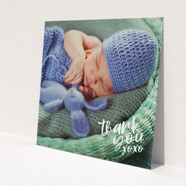 A baby thank you card design named 'Thanks In the Corner'. It is a square (148mm x 148mm) card in a square orientation. It is a photographic baby thank you card with room for 1 photo. 'Thanks In the Corner' is available as a flat card, with mainly white colouring.
