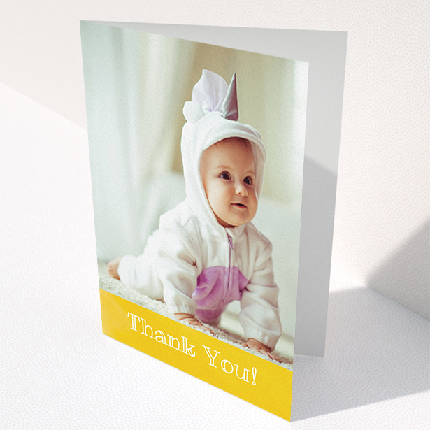 A baby thank you card called "Thanks In Yellow". It is an A6 card in a portrait orientation. It is a photographic baby thank you card with room for 1 photo. "Thanks In Yellow" is available as a folded card, with tones of yellow and white.