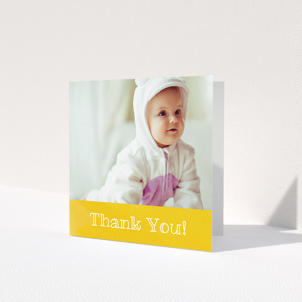 A baby thank you card template titled 'Thanks In Yellow'. It is a square (148mm x 148mm) card in a square orientation. It is a photographic baby thank you card with room for 1 photo. 'Thanks In Yellow' is available as a folded card, with tones of yellow and white.