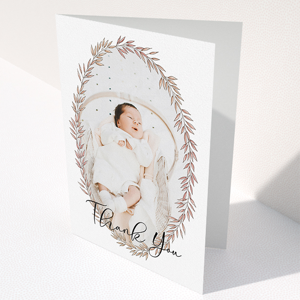 A baby thank you card called "Tussled Wreath". It is an A5 card in a portrait orientation. It is a photographic baby thank you card with room for 1 photo. "Tussled Wreath" is available as a folded card, with mainly pink colouring.