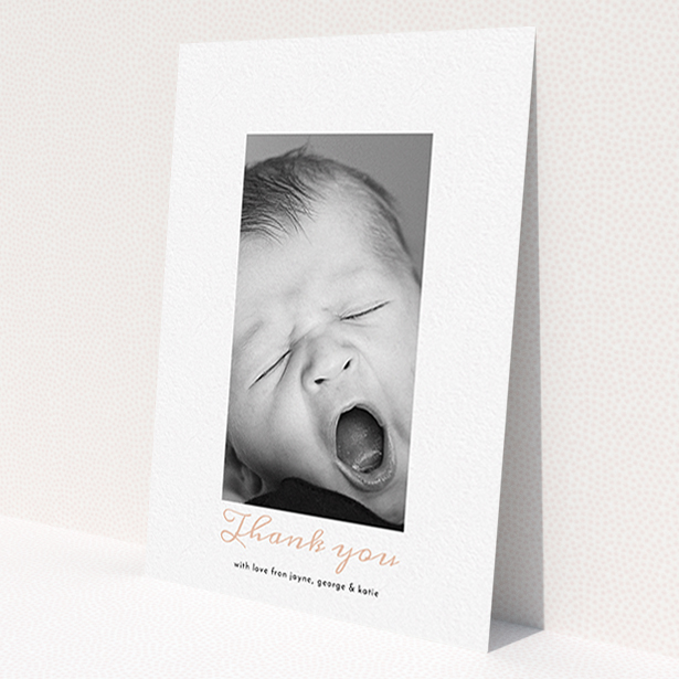 A baptism thank you card design called 'Central Portrait'. It is an A6 card in a portrait orientation. It is a photographic baptism thank you card with room for 1 photo. 'Central Portrait' is available as a flat card, with tones of white and pink.