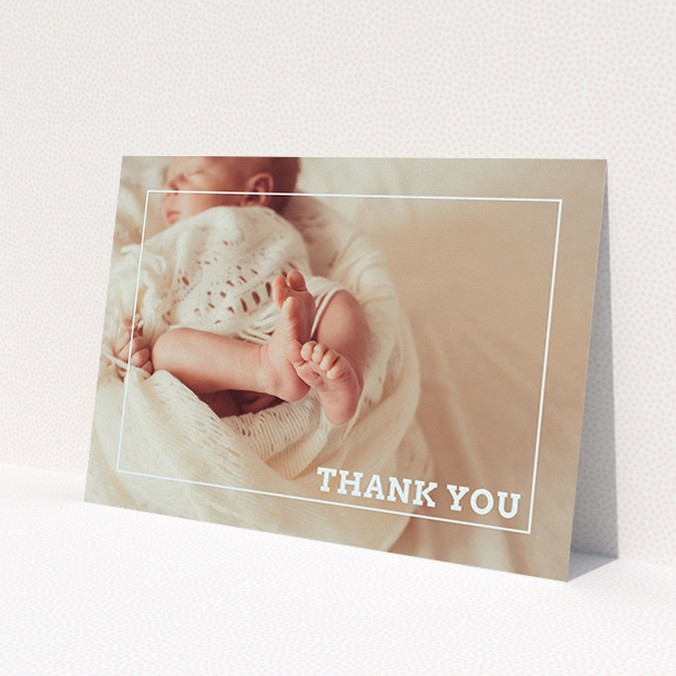 A baptism thank you card named 'Over Photo Frame'. It is an A5 card in a landscape orientation. It is a photographic baptism thank you card with room for 1 photo. 'Over Photo Frame' is available as a flat card, with mainly pale pink colouring.