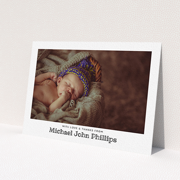 A baptism thank you card named 'Simple Photo Frame'. It is an A6 card in a landscape orientation. It is a photographic baptism thank you card with room for 1 photo. 'Simple Photo Frame' is available as a flat card, with mainly white colouring.