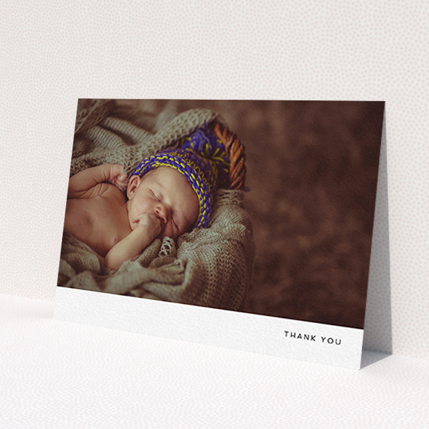 A baptism thank you card design titled 'Thankful with Simplicity'. It is an A6 card in a landscape orientation. It is a photographic baptism thank you card with room for 1 photo. 'Thankful with Simplicity' is available as a flat card, with mainly white colouring.