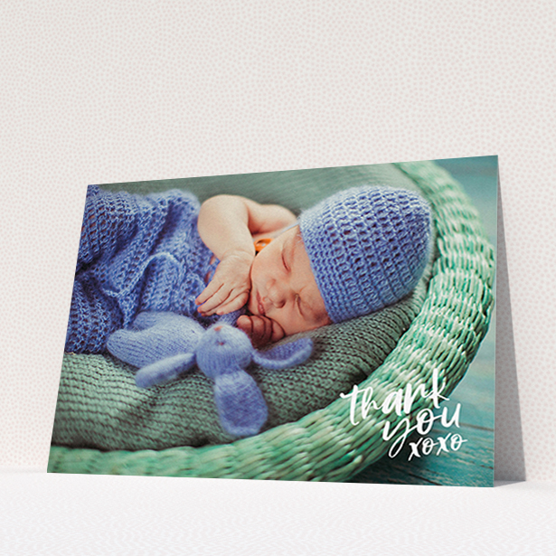 A baptism thank you card design called "Thanks In the Corner". It is an A6 card in a landscape orientation. It is a photographic baptism thank you card with room for 1 photo. "Thanks In the Corner" is available as a flat card, with mainly white colouring.