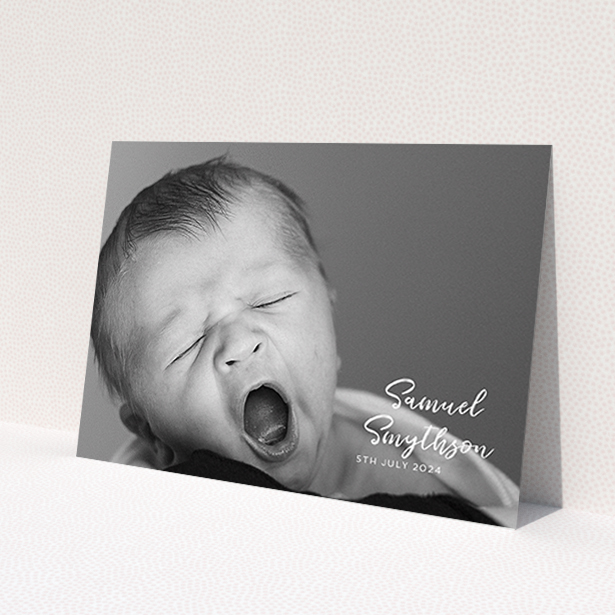 A christening invite named 'Soho Script'. It is an A6 invite in a landscape orientation. It is a photographic christening invite with room for 1 photo. 'Soho Script' is available as a flat invite, with mainly white colouring.