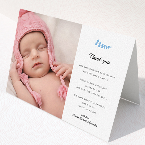 A christening thank you card design named "Blue Fern". It is an A6 card in a landscape orientation. It is a photographic christening thank you card with room for 1 photo. "Blue Fern" is available as a folded card, with tones of white and blue.
