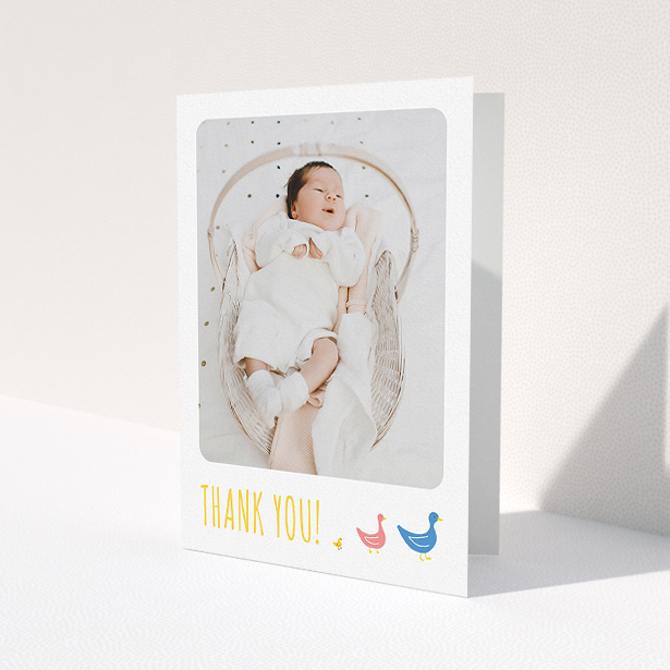 A christening thank you card named "Family of Ducks". It is an A5 card in a portrait orientation. It is a photographic christening thank you card with room for 1 photo. "Family of Ducks" is available as a folded card, with tones of yellow, blue and pink.
