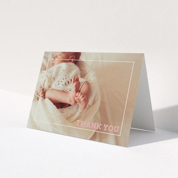 A christening thank you card design called 'Over Photo Frame'. It is an A5 card in a landscape orientation. It is a photographic christening thank you card with room for 1 photo. 'Over Photo Frame' is available as a folded card, with mainly light pink colouring.