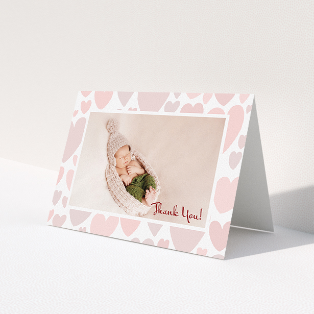 A christening thank you card template titled 'Pastel Hearts'. It is an A5 card in a landscape orientation. It is a photographic christening thank you card with room for 1 photo. 'Pastel Hearts' is available as a folded card, with tones of pink and white.