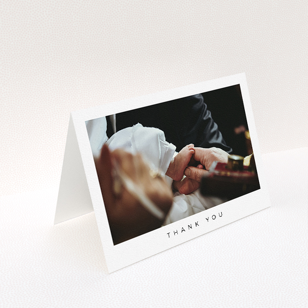 A christening thank you card design named "Simple Thanks". It is an A5 card in a landscape orientation. It is a photographic christening thank you card with room for 1 photo. "Simple Thanks" is available as a folded card, with mainly white colouring.