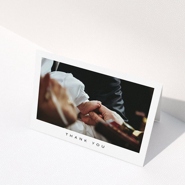 A christening thank you card design named "Simple Thanks". It is an A5 card in a landscape orientation. It is a photographic christening thank you card with room for 1 photo. "Simple Thanks" is available as a folded card, with mainly white colouring.