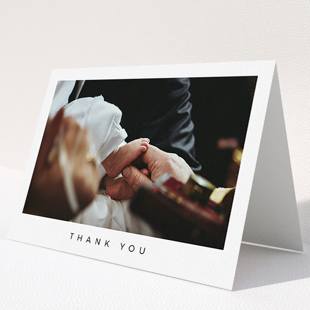 A christening thank you card design named "Simple Thanks". It is an A5 card in a landscape orientation. It is a photographic christening thank you card with room for 1 photo. "Simple Thanks" is available as a folded card, with mainly white colouring.