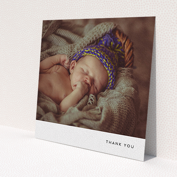 A christening thank you card design named 'Thankful with Simplicity'. It is a square (148mm x 148mm) card in a square orientation. It is a photographic christening thank you card with room for 1 photo. 'Thankful with Simplicity' is available as a flat card, with mainly white colouring.