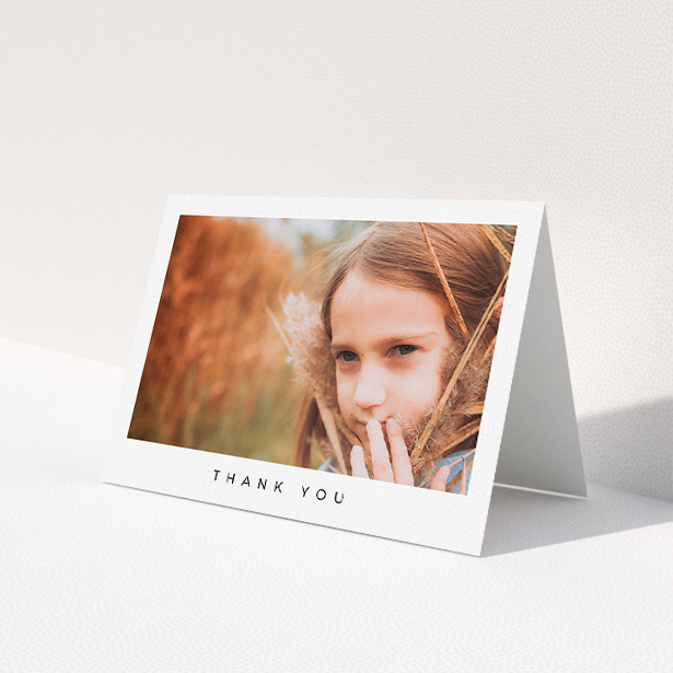 A communion thank you card design titled 'Simple Thanks'. It is an A5 card in a landscape orientation. It is a photographic communion thank you card with room for 1 photo. 'Simple Thanks' is available as a folded card, with mainly white colouring.