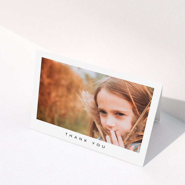 A communion thank you card design titled "Simple Thanks". It is an A5 card in a landscape orientation. It is a photographic communion thank you card with room for 1 photo. "Simple Thanks" is available as a folded card, with mainly white colouring.