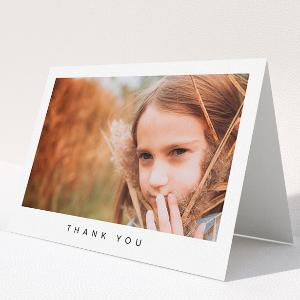 A communion thank you card design titled "Simple Thanks". It is an A5 card in a landscape orientation. It is a photographic communion thank you card with room for 1 photo. "Simple Thanks" is available as a folded card, with mainly white colouring.