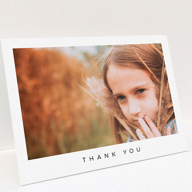 A communion thank you card design titled "Simple Thanks". It is an A5 card in a landscape orientation. It is a photographic communion thank you card with room for 1 photo. "Simple Thanks" is available as a folded card, with mainly white colouring.