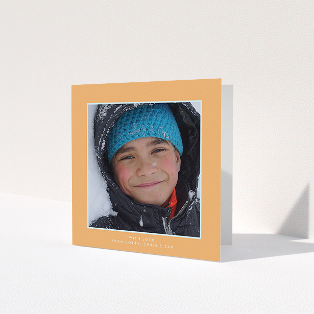 A first holy communion thank you card named 'Orange and Mint'. It is a square (148mm x 148mm) card in a square orientation. It is a photographic first holy communion thank you card with room for 1 photo. 'Orange and Mint' is available as a folded card, with tones of orange and blue.