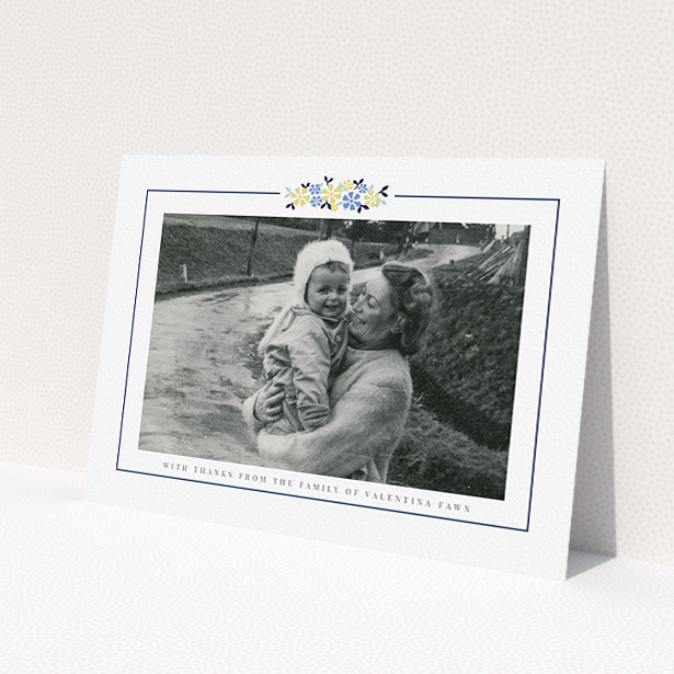 A funeral thank you card design titled 'Remembered in flowers'. It is an A5 card in a landscape orientation. It is a photographic funeral thank you card with room for 1 photo. 'Remembered in flowers' is available as a flat card, with tones of white and blue.