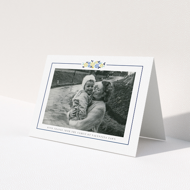 A funeral thank you card template titled 'Remembered in flowers'. It is an A5 card in a landscape orientation. It is a photographic funeral thank you card with room for 1 photo. 'Remembered in flowers' is available as a folded card, with tones of white and blue.