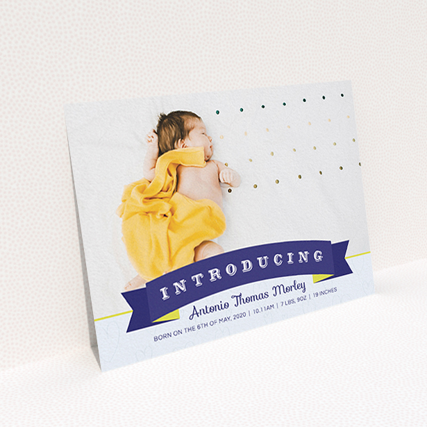 A new baby announcement card named "Big Banner". It is an A6 card in a landscape orientation. It is a photographic new baby announcement card with room for 1 photo. "Big Banner" is available as a flat card, with tones of blue, light blue and yellow.