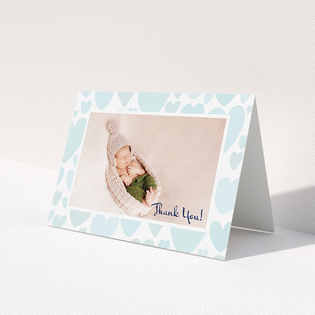 A new baby thank you card design titled 'Pastel Hearts'. It is an A5 card in a landscape orientation. It is a photographic new baby thank you card with room for 1 photo. 'Pastel Hearts' is available as a folded card, with tones of blue and white.