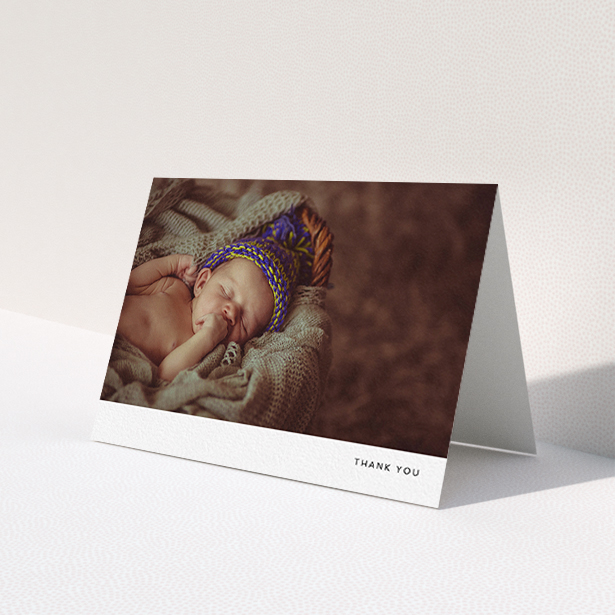 A new baby thank you card design named 'Thankful with Simplicity'. It is an A6 card in a landscape orientation. It is a photographic new baby thank you card with room for 1 photo. 'Thankful with Simplicity' is available as a folded card, with mainly white colouring.