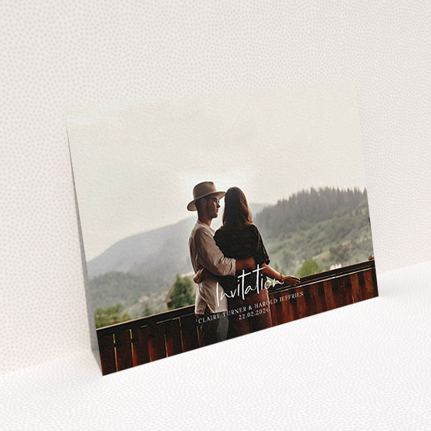 A personalised wedding invite named "Central Script". It is an A6 invite in a landscape orientation. It is a photographic personalised wedding invite with room for 1 photo. "Central Script" is available as a flat invite, with mainly white colouring.