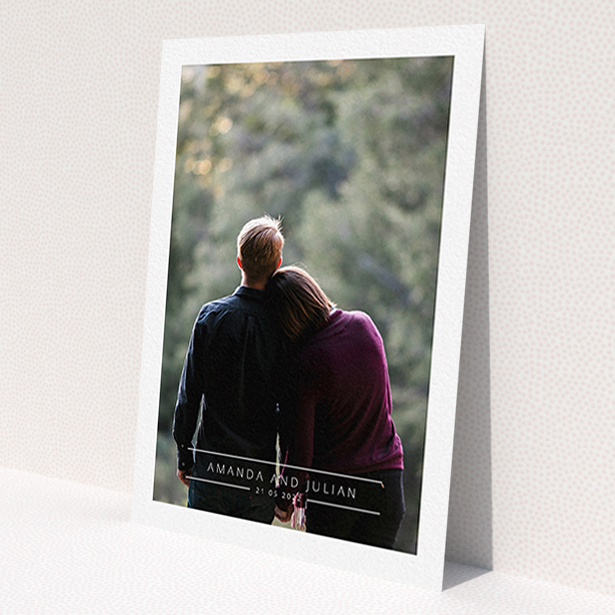 A personalised wedding invite named 'Tramlines'. It is an A6 invite in a portrait orientation. It is a photographic personalised wedding invite with room for 1 photo. 'Tramlines' is available as a flat invite, with mainly white colouring.