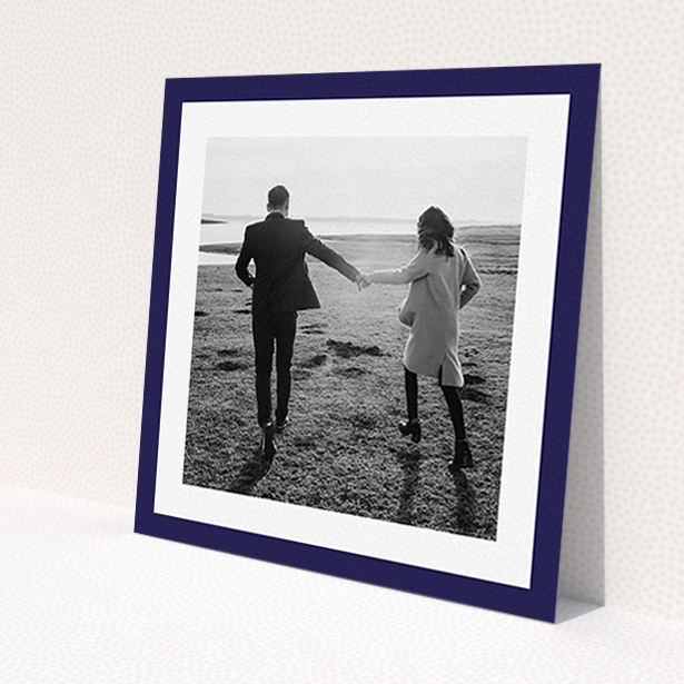A wedding save the date card design named 'Classic Navy Photo Frame'. It is a square (148mm x 148mm) card in a square orientation. It is a photographic wedding save the date card with room for 1 photo. 'Classic Navy Photo Frame' is available as a flat card, with tones of blue and white.