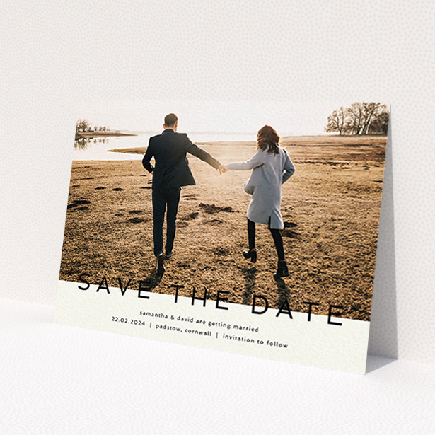 A wedding save the date card called 'Simple Saving'. It is an A6 card in a landscape orientation. It is a photographic wedding save the date card with room for 1 photo. 'Simple Saving' is available as a flat card, with tones of cream and black.
