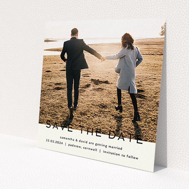 A wedding save the date card design called 'Simple Saving'. It is a square (148mm x 148mm) card in a square orientation. It is a photographic wedding save the date card with room for 1 photo. 'Simple Saving' is available as a flat card, with tones of cream and black.
