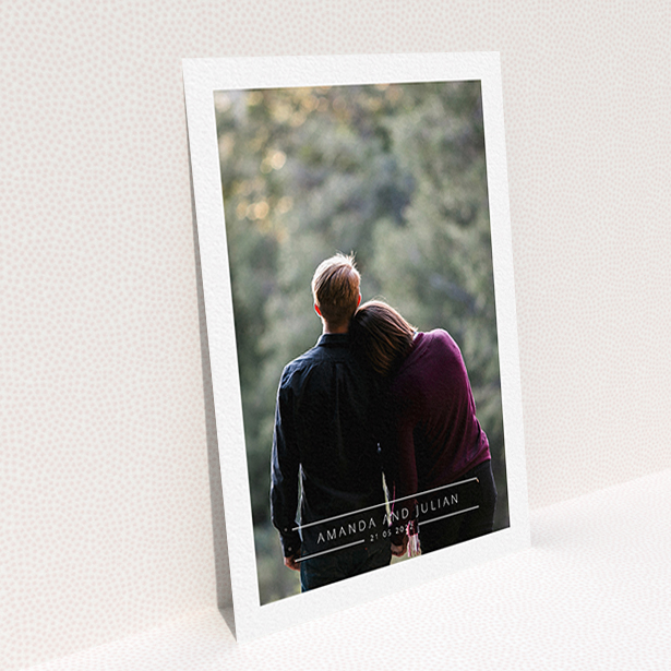 A wedding save the date card design called "Tramlines". It is an A6 card in a portrait orientation. It is a photographic wedding save the date card with room for 1 photo. "Tramlines" is available as a flat card, with mainly white colouring.
