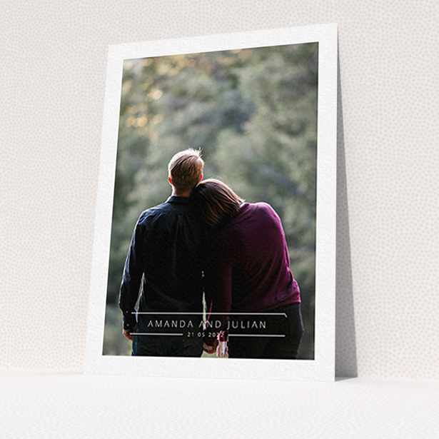 A wedding save the date card design called "Tramlines". It is an A6 card in a portrait orientation. It is a photographic wedding save the date card with room for 1 photo. "Tramlines" is available as a flat card, with mainly white colouring.