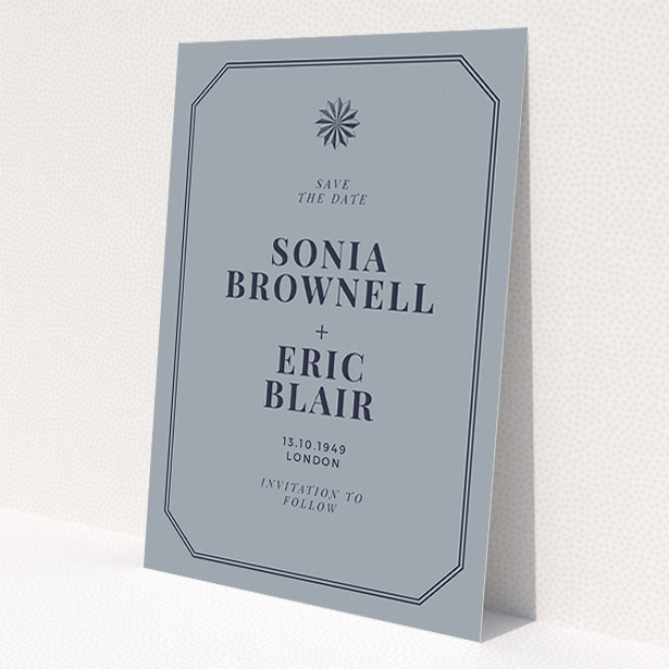 A wedding save the date template titled 'Shaded sundial'. It is an A5 save the date in a portrait orientation. 'Shaded sundial' is available as a flat save the date, with tones of dark grey and navy blue.