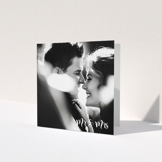A wedding thank you card template titled 'Black and White'. It is a square (148mm x 148mm) card in a square orientation. It is a photographic wedding thank you card with room for 1 photo. 'Black and White' is available as a folded card, with mainly white colouring.