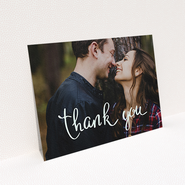 A wedding thank you card design titled "Curly thank you". It is an A6 card in a landscape orientation. It is a photographic wedding thank you card with room for 1 photo. "Curly thank you" is available as a flat card, with mainly white colouring.