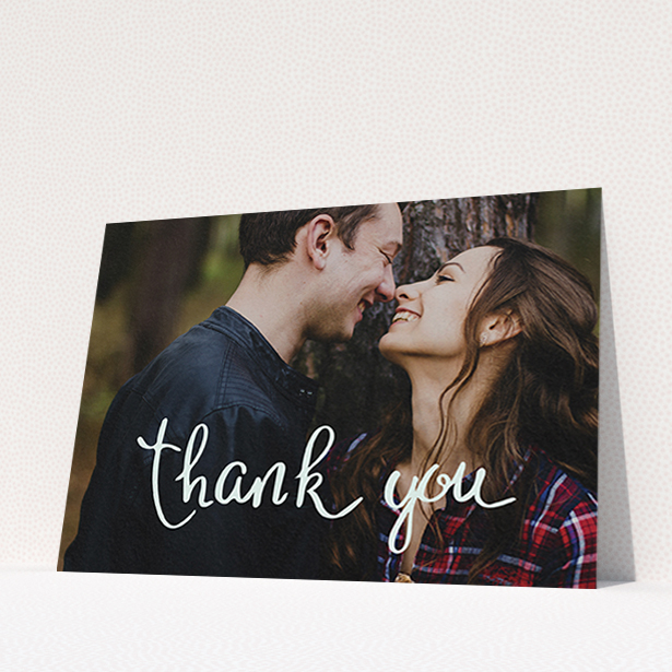 A wedding thank you card design titled "Curly thank you". It is an A6 card in a landscape orientation. It is a photographic wedding thank you card with room for 1 photo. "Curly thank you" is available as a flat card, with mainly white colouring.