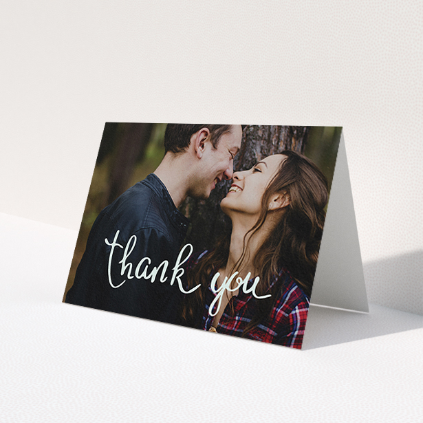 A wedding thank you card design called 'Curly thank you'. It is an A6 card in a landscape orientation. It is a photographic wedding thank you card with room for 1 photo. 'Curly thank you' is available as a folded card, with mainly white colouring.