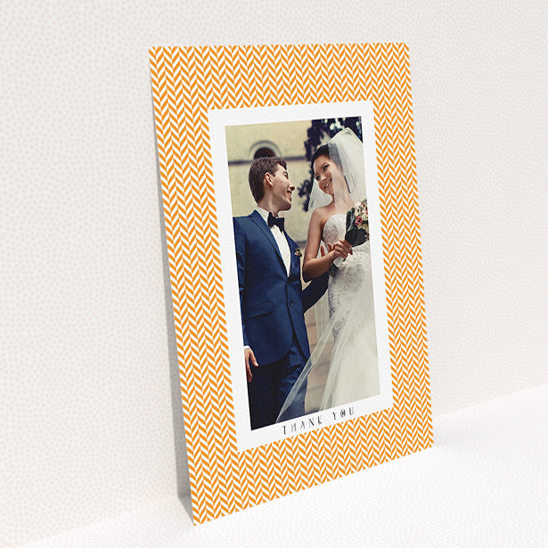 A wedding thank you card design titled "Orange Houndstooth". It is an A5 card in a portrait orientation. It is a photographic wedding thank you card with room for 1 photo. "Orange Houndstooth" is available as a flat card, with tones of orange and white.