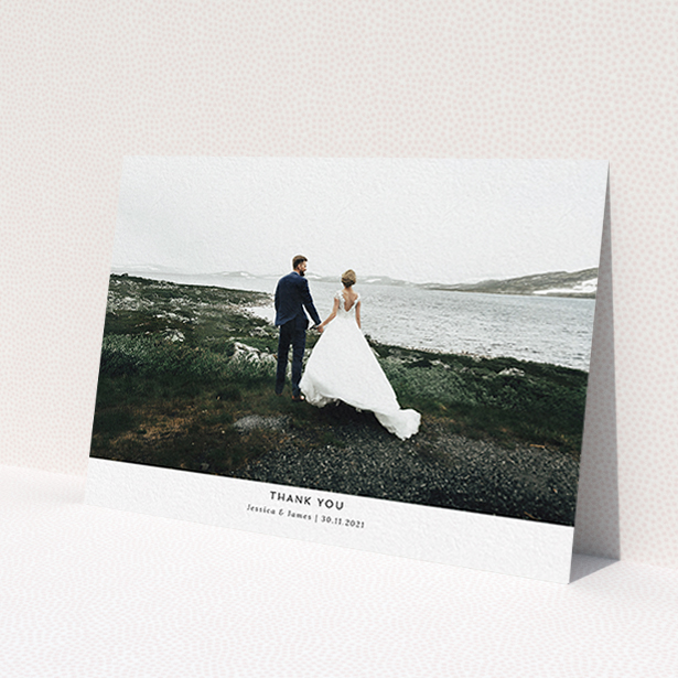 A wedding thank you card design named "Sans Serif". It is an A6 card in a landscape orientation. It is a photographic wedding thank you card with room for 1 photo. "Sans Serif" is available as a flat card, with mainly white colouring.