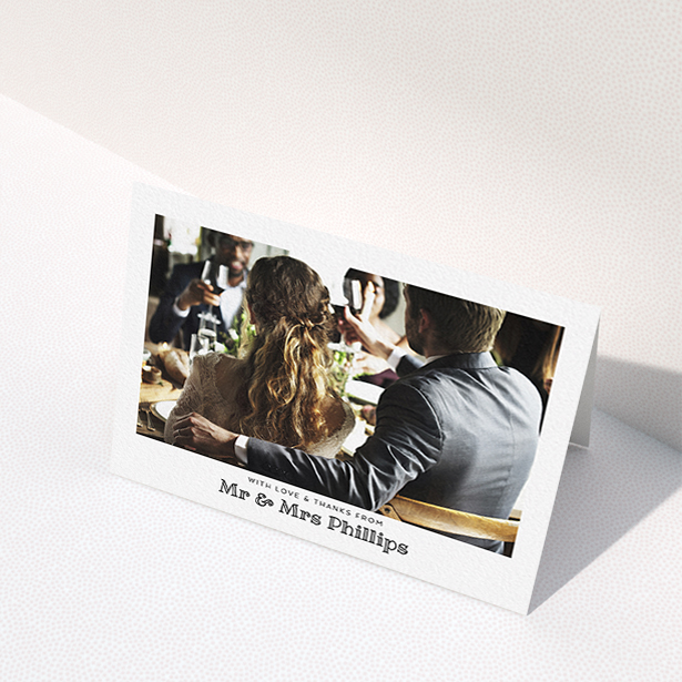 A wedding thank you card template titled "Simple Photo Frame". It is an A6 card in a landscape orientation. It is a photographic wedding thank you card with room for 1 photo. "Simple Photo Frame" is available as a folded card, with mainly white colouring.