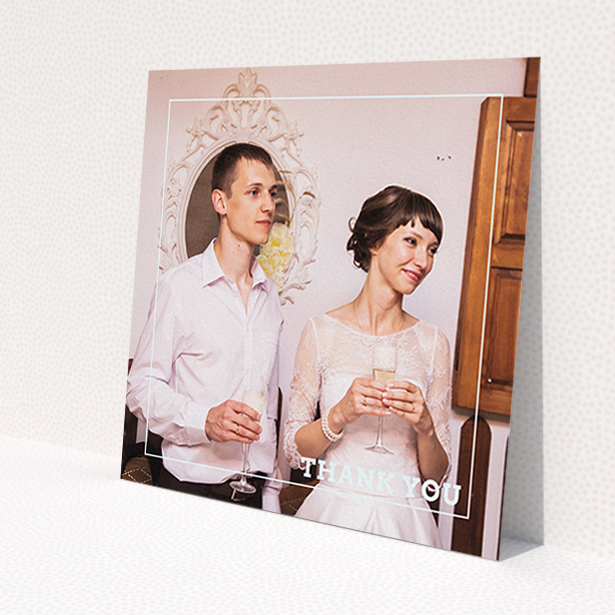 A wedding thank you card design named 'Simple Thank You Frame'. It is a square (148mm x 148mm) card in a square orientation. It is a photographic wedding thank you card with room for 1 photo. 'Simple Thank You Frame' is available as a flat card, with mainly white colouring.